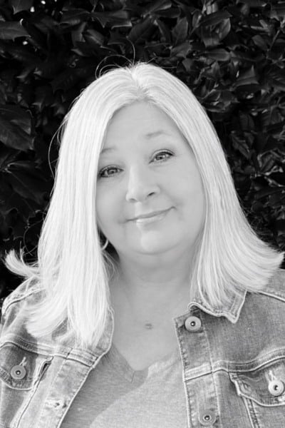 Christy team member headshot outdoors with greenery background